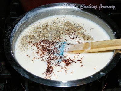 Adding saffron, cardamom powder to ice cream mixture Adding saffron, cardamom powder to ice cream mixture