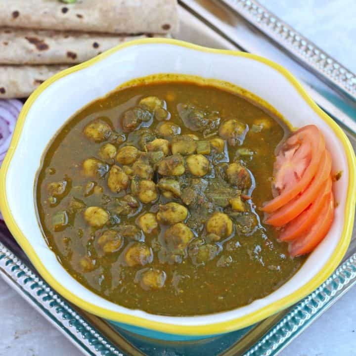 chickpeas in spinach curry with sliced tomatoes as garnish