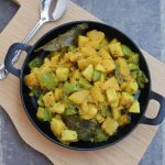 Mixed vegetable curry top view on a black plate.