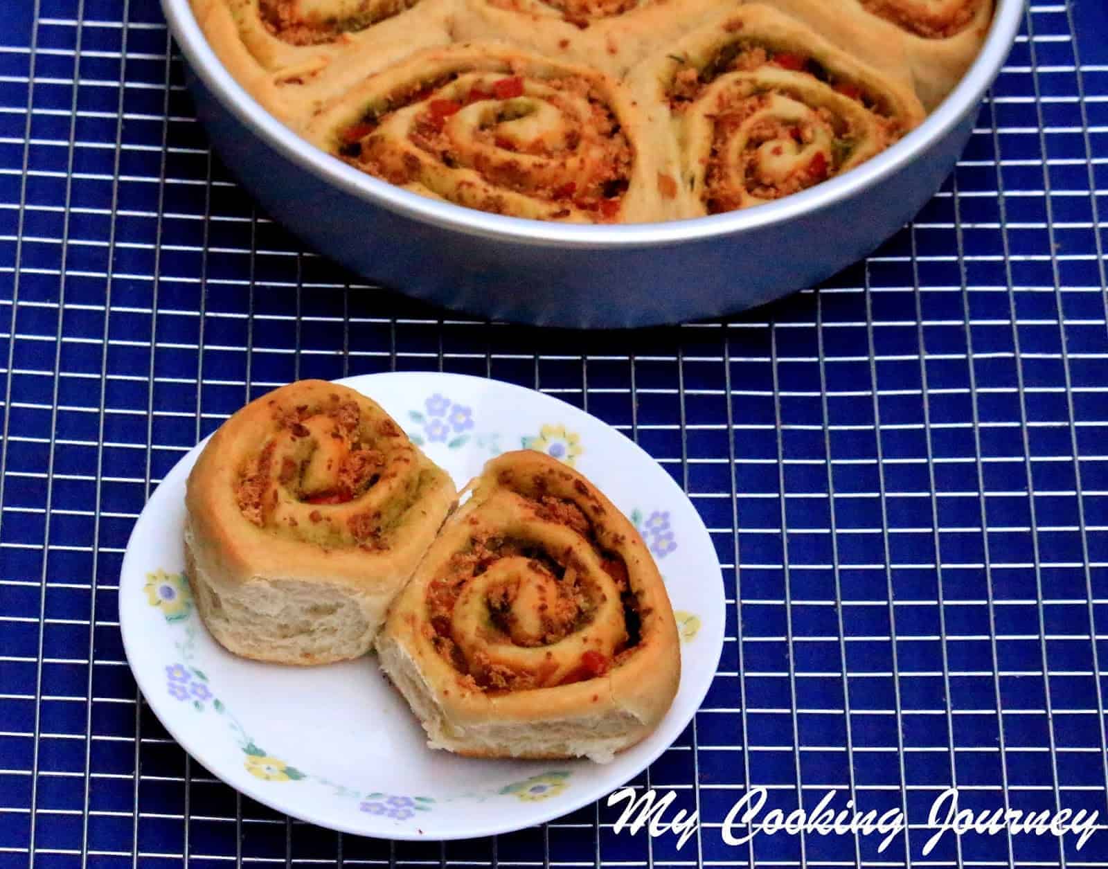 Savory Swirl Buns in a baking pan and white plate
