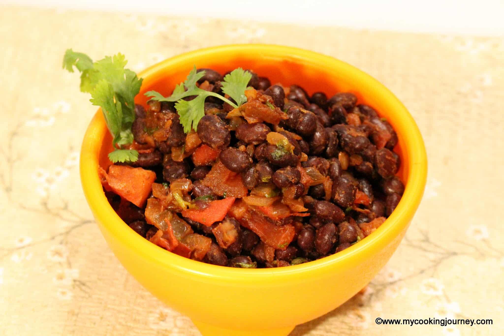 Warm black bean salad in a yellow bowl with cilantro