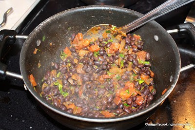 black beans, tomato and onion in a pan