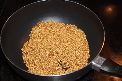 frying coriander seeds in a pan