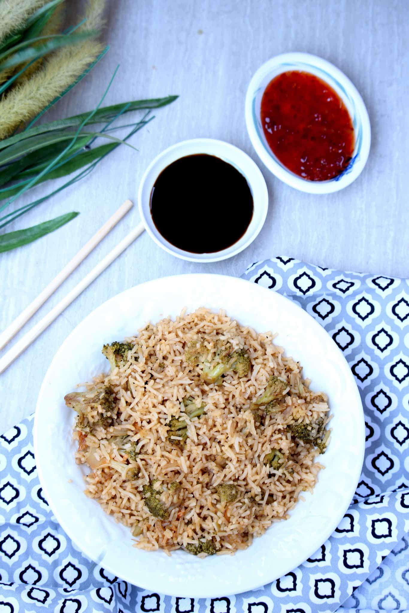 Broccoli Fried Rice with soy sauce and chili sauce on the background