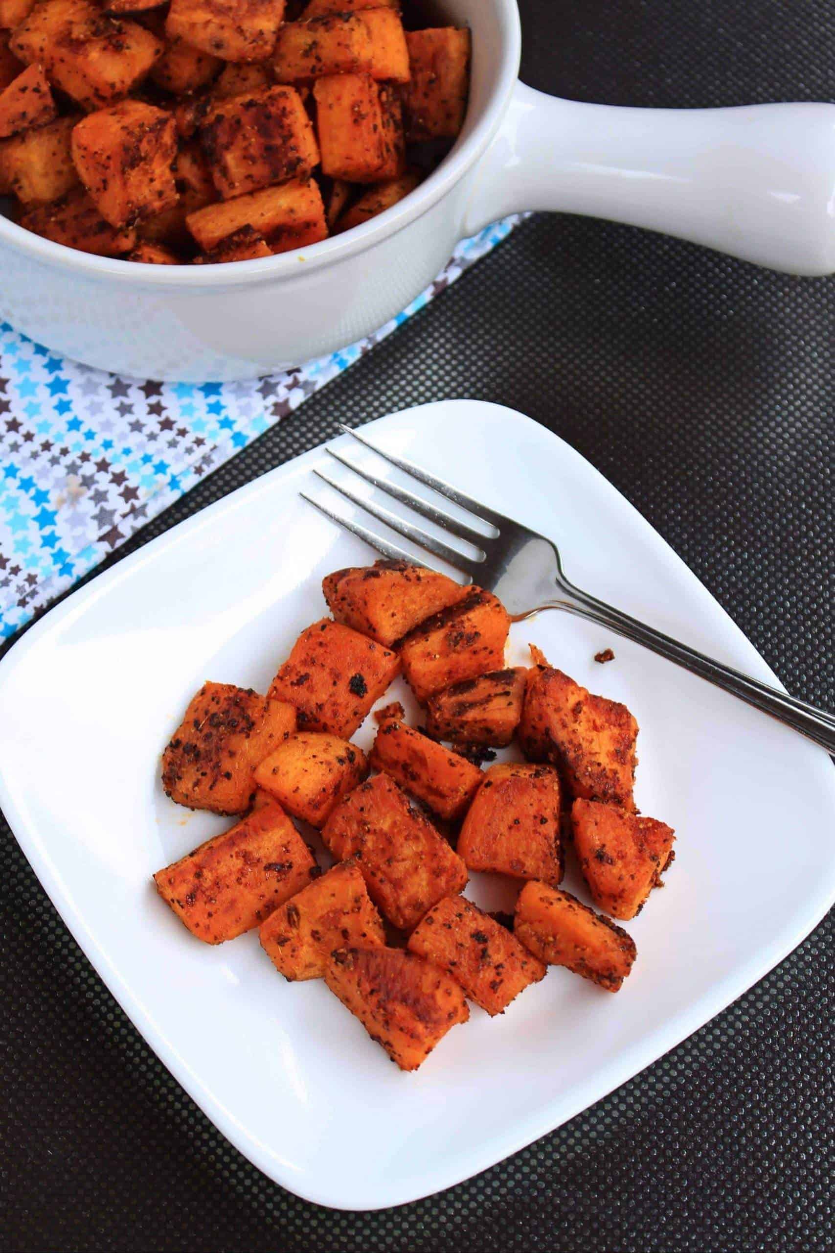 Roasted Sweet Potatoes in a Plate with Spoon.