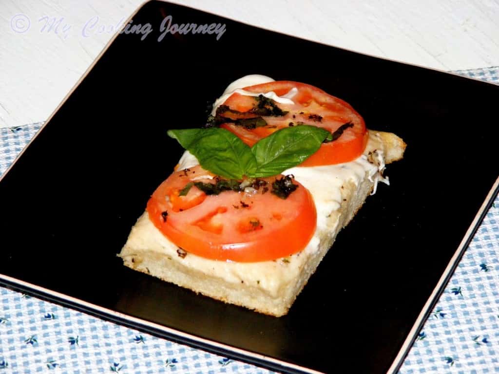 Foccacia Caprese Topped With Tomatoes, Mozzarella and Basil in a tray