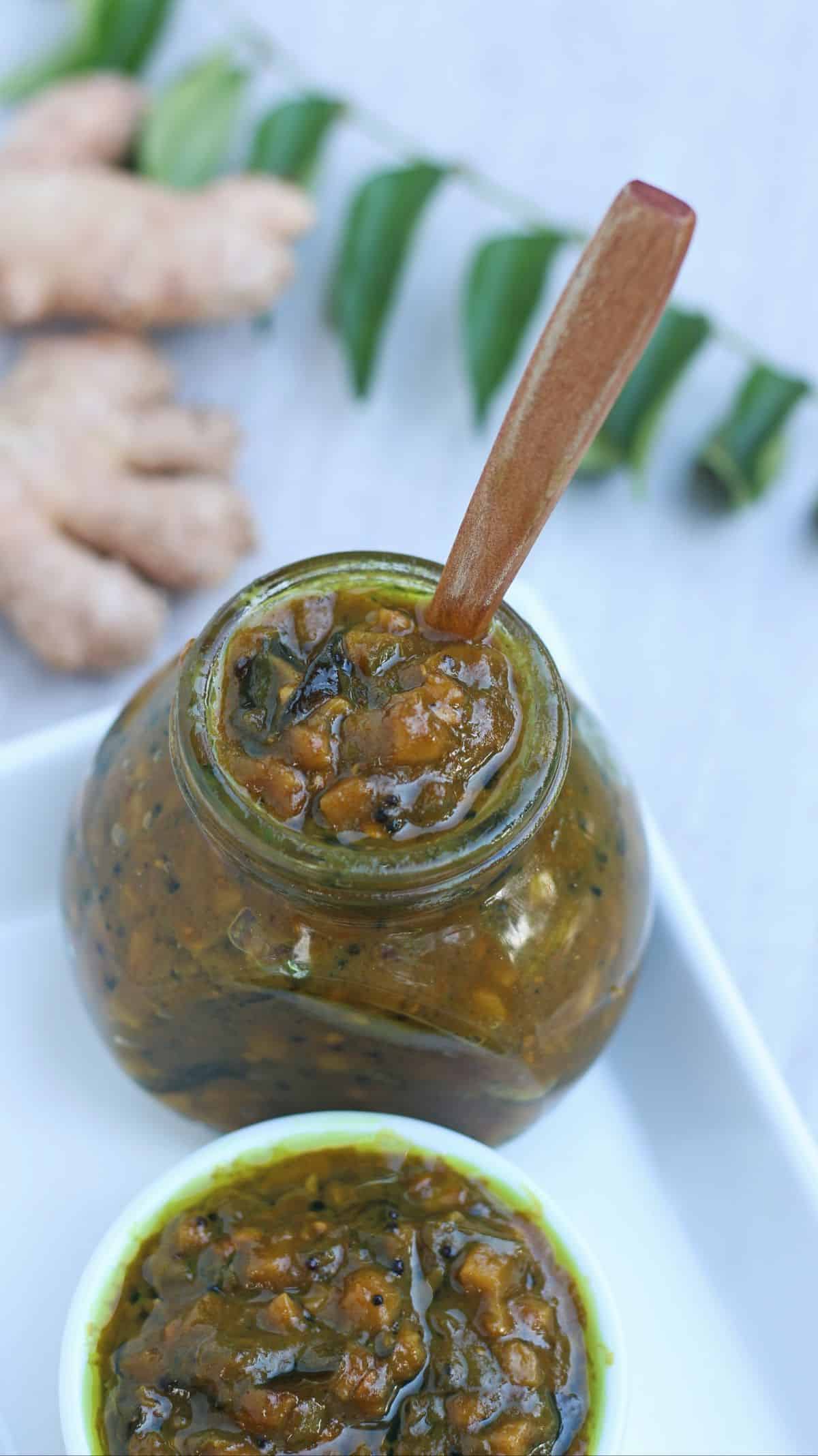 ginger and green chili pickle in a jar with wooden spoon