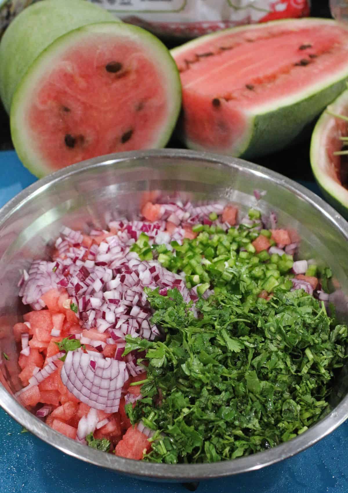 watermelon pieces, onions, jalapeno and cilantro in a bowl
