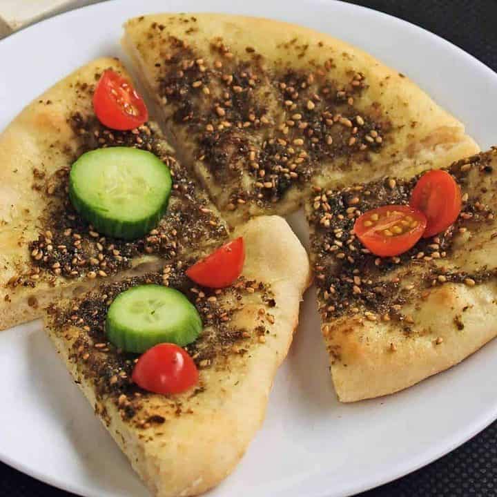 Zaatar Flatbread with cucumbers and tomatoes on top - Featured Image