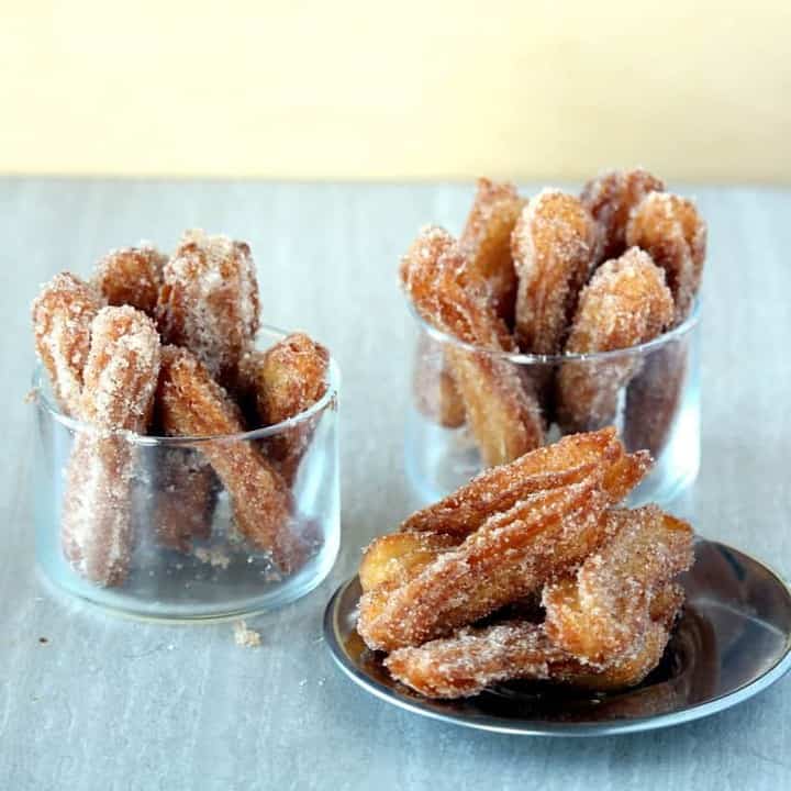 Churros in plate and cups - Featured Image