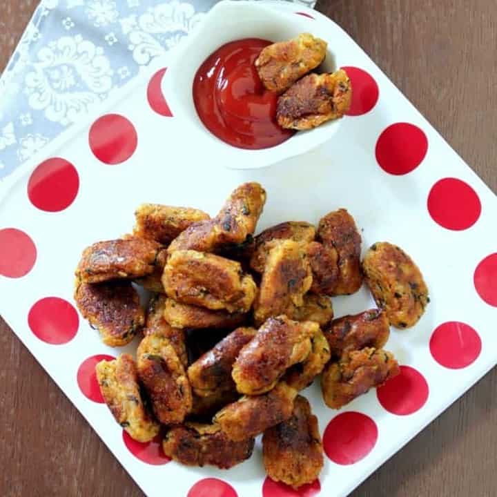 Zucchini Potato tots in a white plate with ketchup on the side - Featured Image.