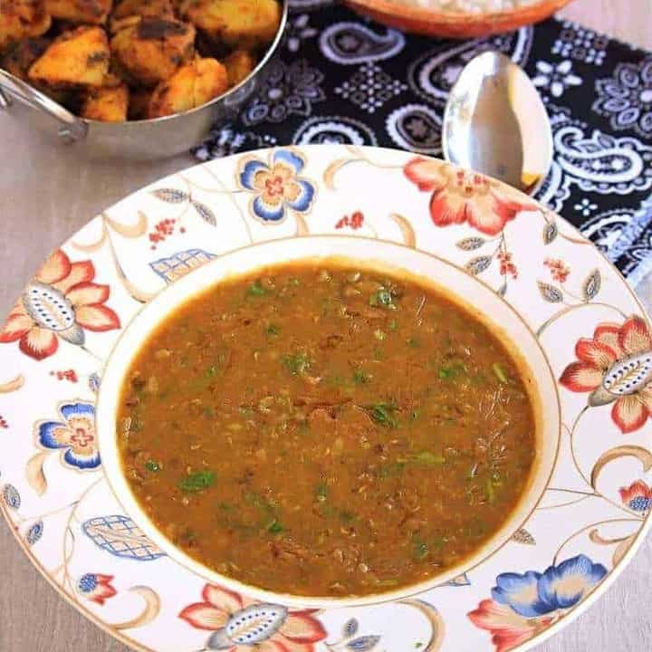 Khatta Meeta Moon Dal in a white bowl with sides - Featured Image