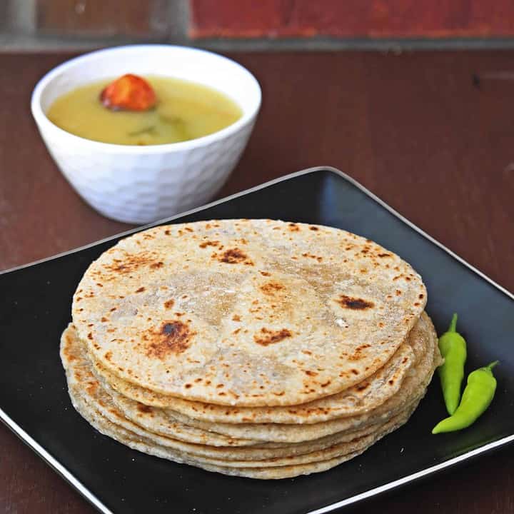 Pol Roti in a black plate with Dhal - Featured Image