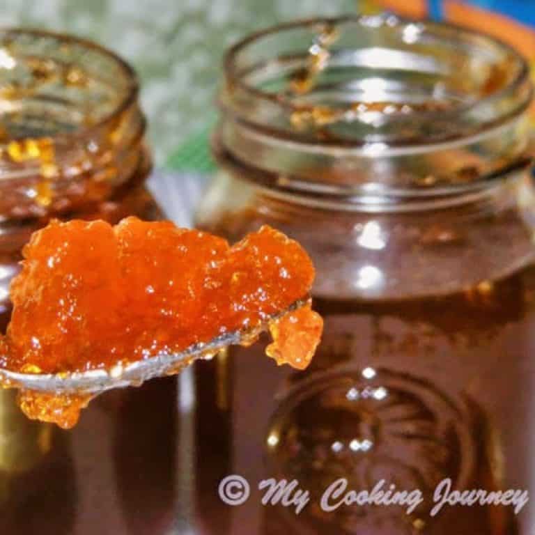 Jalapeno Jelly in a spoon with rest in the jars in background - Feature Image